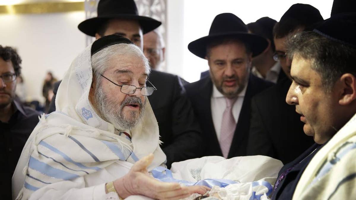 In this Feb. 11, 2015 photo, Abraham Romi Cohn, left, performs the bris, or ritual circumcision, of Yosef Sananas in New York. Mayor Bill de Blasio’s administration is negotiating a medical protocol that would allow for religious freedom as it navigates health officials' concern over the practice of oral suction during ultra-Orthodox circumcision ceremonies, in which a rabbi sucks blood from a wound on the penis. (AP Photo/Seth Wenig)
