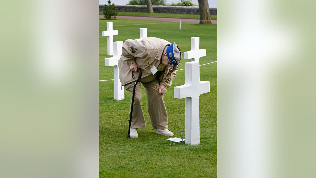 U.S. WW II veteran paying respects at grave of WWII soldier