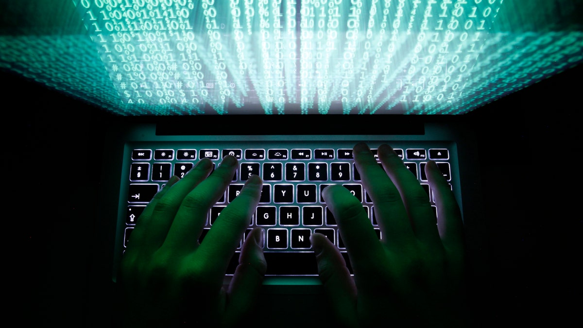 A man typing on a laptop 