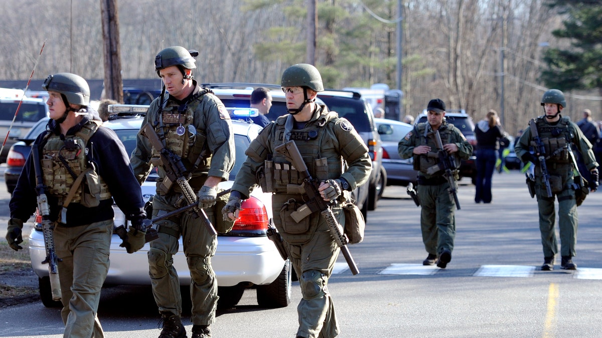 State Police are on scene following a shooting at the Sandy Hook Elementary School in Newtown, Conn., about 60 miles (96 kilometers) northeast of New York City, Friday, Dec. 14, 2012. An official with knowledge of Friday's shooting said 27 people were dead, including 18 children. (AP Photo/Jessica Hill)