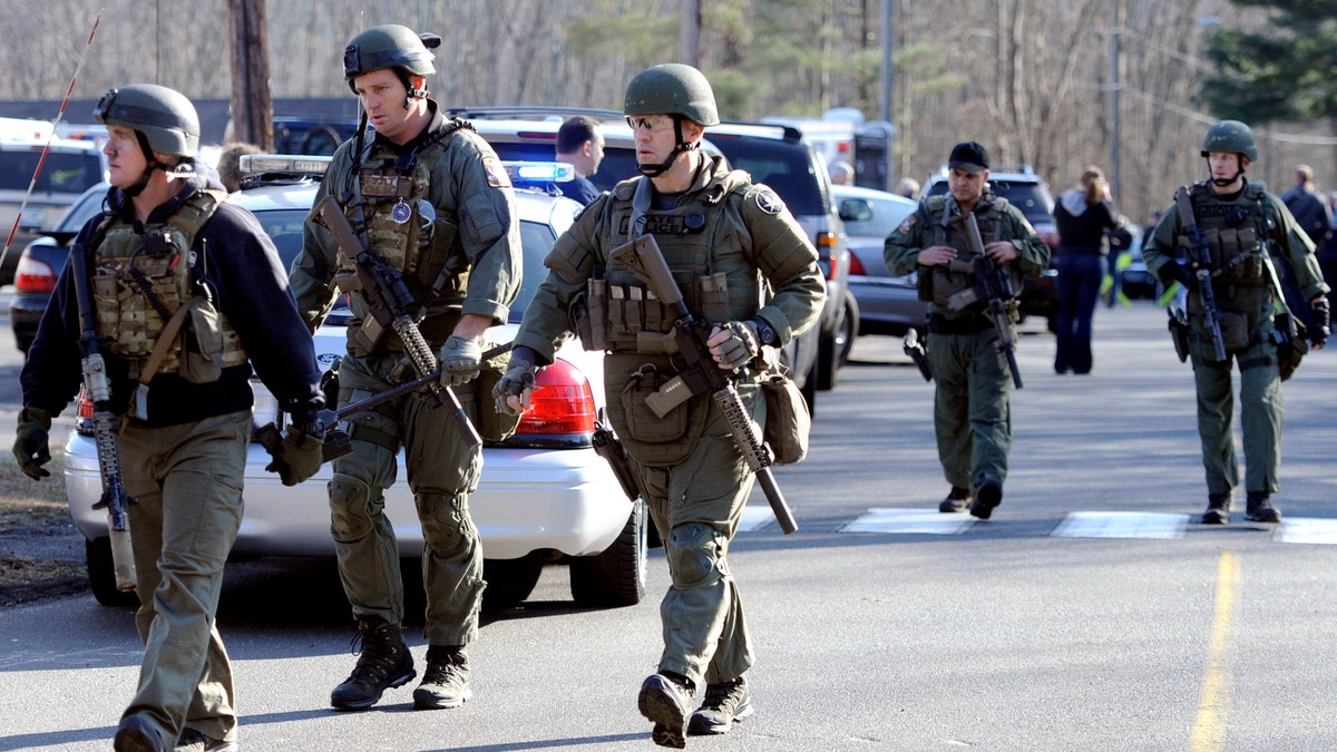 State Police are on scene following a shooting at the Sandy Hook Elementary School in Newtown, Conn., about 60 miles (96 kilometers) northeast of New York City, Friday, Dec. 14, 2012. An official with knowledge of Friday's shooting said 27 people were dead, including 18 children. (AP Photo/Jessica Hill)