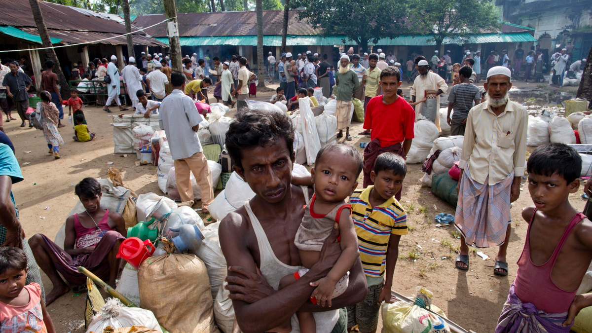 In this Monday, Oct. 2, 2017, file photo, newly arrived Rohingya Muslims from Myanmar prepare to leave a transit shelter in Shahparirdwip, Bangladesh. A team of independent investigators examining alleged violence and killings in Myanmar that caused hundreds of thousands of Rohingya Muslims to flee their homes have issued a searing critique of the United Nations' own operations in the country just as bloodshed erupted in August 2017. (AP Photo/Gemunu Amarasinghe, File)