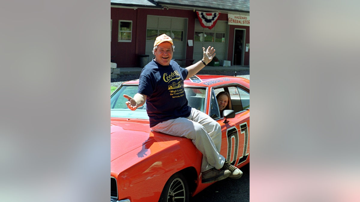 In this Aug. 10, 1999, file photo, 'Cooter,' actor Ben Jones, sits atop one of the 229 hotrods, named The General Lee, used in the show 'Dukes of Hazzard' in front of his store in Sperryville, Va.