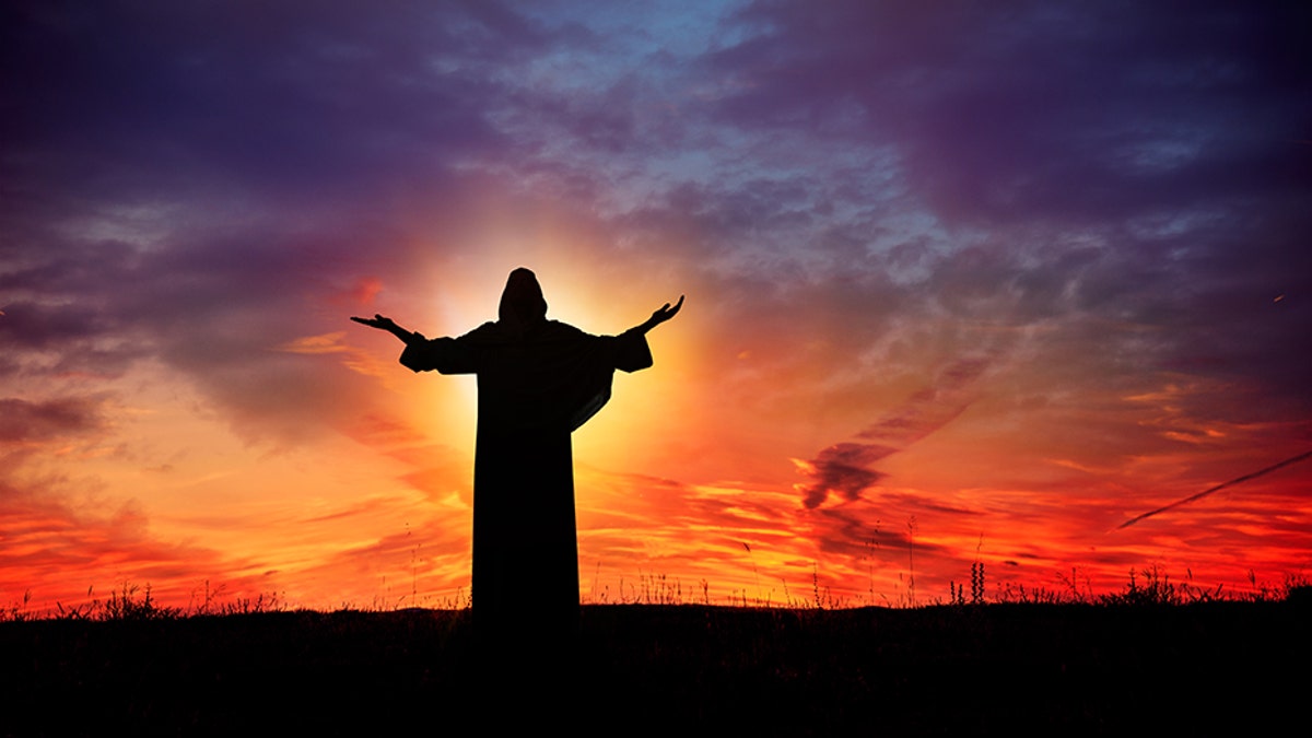 Man praying at sunset