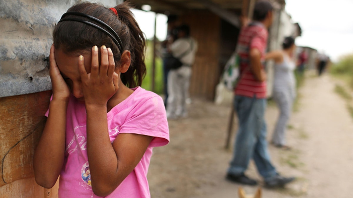 TEGUCIGALPA, HONDURAS - JULY 20:  A young girl cries as her home and neighborhood are forcefully dismantled in a shanty town after the government claimed that the settlement was illegal on July 20, 2012 in Tegucigalpa, Honduras. Land disputes are becoming increasingly frequent in Honduras  which is alarming the nation's business class while sowing fears of increased political violence. In a nation where 72% of the poorest landowners hold only 11.6% of cultivated land, tensions are rising as the poor have few places to go and little opportunities for productive employment. Honduras now has the highest per capita murder rate in the world and its capital city, Tegucigalpa, is plagued by violence, poverty, homelessness and sexual assaults. With an estimated 80% of the cocaine entering the United States now being trans-shipped through Honduras, the violence on the streets is a spillover from the ramped rise in narco-trafficking.  (Photo by Spencer Platt/Getty Images)