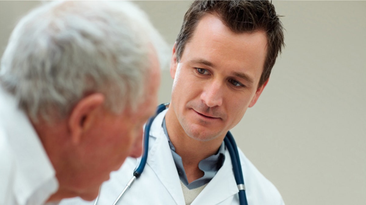 Young doctor conversing with an elderly patient