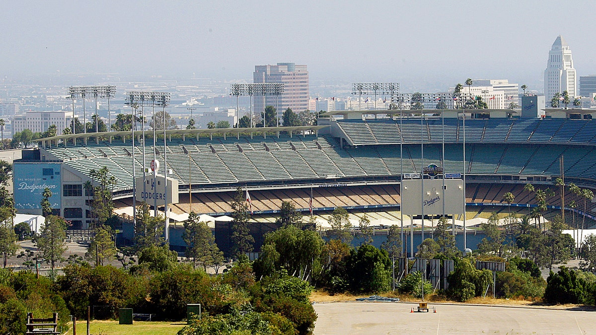 FILE - In this June 20, 2011, file photo, Dodger Stadium, home of baseball's Los Angeles Dodgers, with City Hall visible in right background. The Los Angeles Dodgers and Major League Baseball have agreed on a process to sell the team. In a joint statement released late Tuesday, Nov. 1, 2011, both sides say they have agreed "to a court supervised process to sell the team." The agreement also includes the sale of team media rights "to realize maximum value for the Dodgers and their owner, Frank McCourt." (AP Photo/Reed Saxon, File)