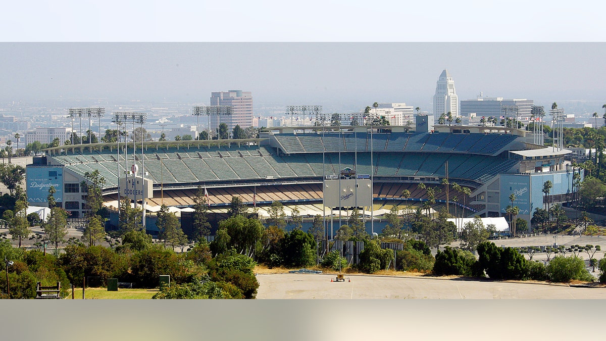 FILE - In this June 20, 2011, file photo, Dodger Stadium, home of baseball's Los Angeles Dodgers, with City Hall visible in right background. The Los Angeles Dodgers and Major League Baseball have agreed on a process to sell the team. In a joint statement released late Tuesday, Nov. 1, 2011, both sides say they have agreed "to a court supervised process to sell the team." The agreement also includes the sale of team media rights "to realize maximum value for the Dodgers and their owner, Frank McCourt." (AP Photo/Reed Saxon, File)