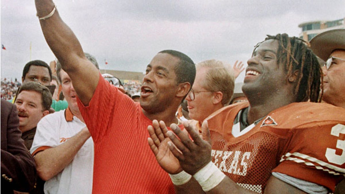 FILE: University of Texas Longhorns Ricky Williams, right, laughs as former Dallas Cowboys star Tony Dorsett signals 'Hook 'em horn' after Williams surpassed Dorsett's NCAA rushing record.