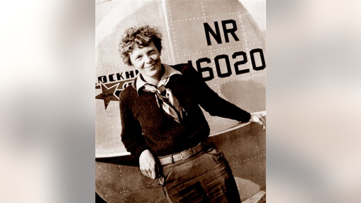 This May 20, 1937 photo, provided by The Paragon Agency, shows aviator Amelia Earhart at the tail of her Electra plane, taken at Burbank Airport in Burbank, Calif. (Albert Bresnik/The Paragon Agency via AP)