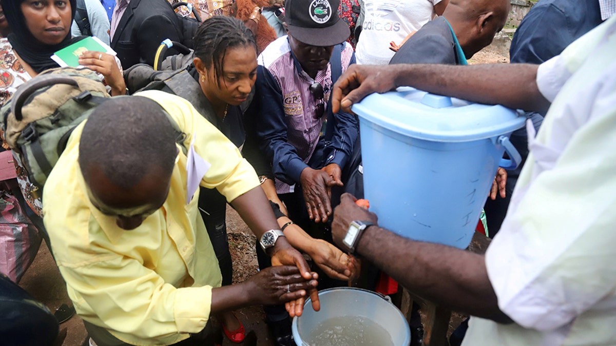 A Congolese health worker instructs residents about washing their hands as a preventive measure against Ebola in Mbandaka, Democratic Republic of Congo