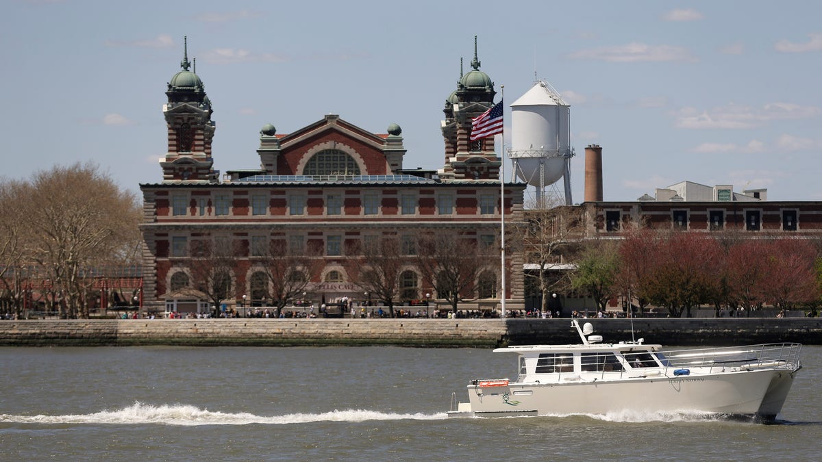 A yacht passes by Ellis Island as it makes its way through New York Harbor, Wednesday, April 29, 2015, in New York. With the unveiling of a new exhibition next month, Ellis Island is telling stories of immigrants who have come as recently as the start of this century. And combined with a section that was opened in 2011 the museum is taking on a broader mission of showcasing the countrys entire migration history. (AP Photo/Julie Jacobson)