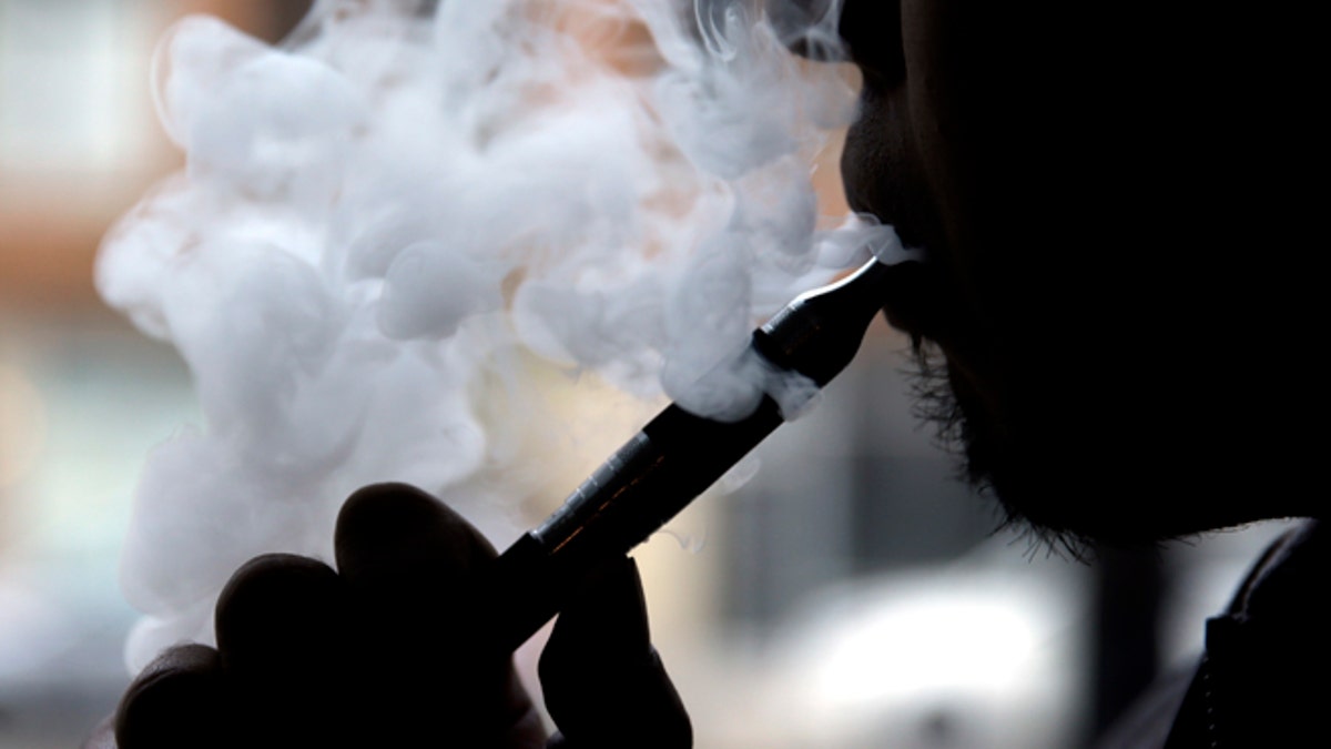 Daryl Cura demonstrates an e-cigarette at Vape store in Chicago, Wednesday, April 23, 2014. The federal government wants to ban sales of electronic cigarettes to minors and require approval for new products and health warning labels under regulations being proposed by the Food and Drug Administration. (AP Photo/Nam Y. Huh)