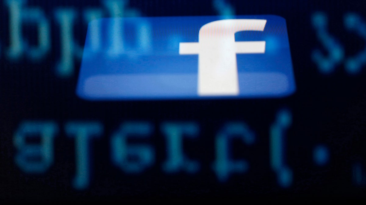File photo - A Facebook logo on an Ipad is reflected among source code on the LCD screen of a computer, in this photo illustration taken in Sarajevo June 18, 2014.  