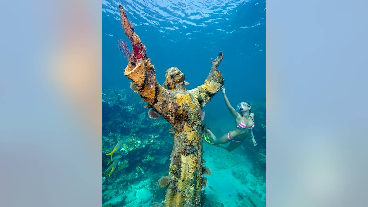Katherine Wieland snorkels by the the "Christ of the Abyss" statue, an underwater icon for John Pennekamp Coral Reef State park, off Key Largo, Fla. Named after a former Miami newspaper editor, Pennekamp is the nation's first underwater preserve. FOR EDITORIAL USE ONLY (Stephen Frink/Florida Keys News Bureau)