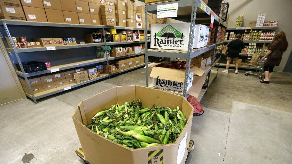 In this July 29, 2015 photo, a load of sweet corn sits ready to be given away at the Des Moines Area Religious Council food pantry in Des Moines, Iowa. Food banks across the country are seeing surging demand for free groceries despite a growing economy and steadily declining unemployment rate, leading some charities to reduce the amount of food they offer each family. 