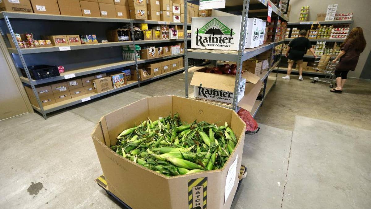 In this July 29, 2015 photo, a load of sweet corn sits ready to be given away at the Des Moines Area Religious Council food pantry in Des Moines, Iowa. Food banks across the country are seeing surging demand for free groceries despite a growing economy and steadily declining unemployment rate, leading some charities to reduce the amount of food they offer each family. 