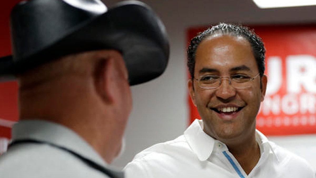 In this Saturday, Aug. 27, 2016 photo, first-term Republican Rep. Will Hurd, right, of Texas, talks with a supporter at a campaign office, in San Antonio. Many House Republican incumbents worry that blowback from Republican presidential nominee Donald Trump's anti-Hispanic rhetoric and promises to build a towering wall the length of the U.S.-Mexico border could hurt their re-election chances, a problem especially acute for those in heavily Latino districts like that of Hurd, whose territory encompasses 820 miles of the U.S.-Mexico border. (AP Photo/Eric Gay)