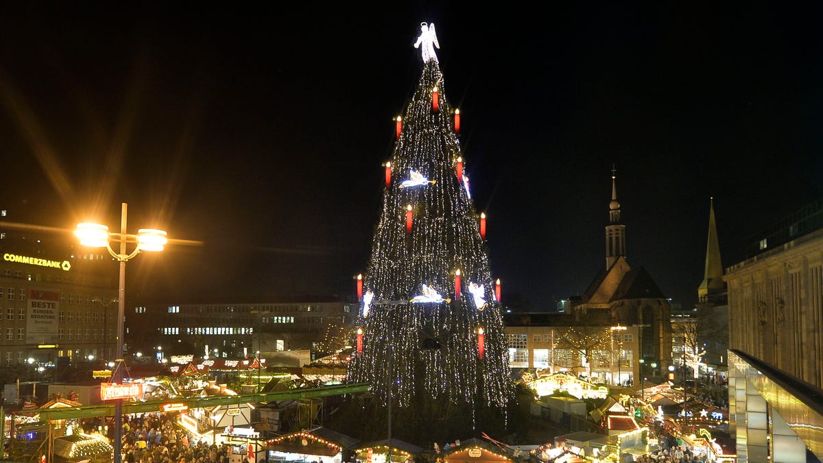 Germany's biggest Christmas tree shines in the center of a Christmas market in Dortmund, Germany, Friday evening, Dec. 13, 2013. The traditional 45 meter tall Christmas tree is illuminated by 48000 lights and made of 1700 red spruces. (AP Photo/Martin Meissner)