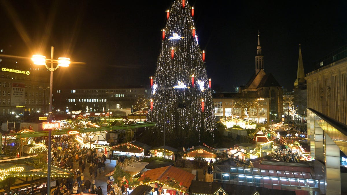 Germany's biggest Christmas tree shines in the center of a Christmas market in Dortmund, Germany, Friday evening, Dec. 13, 2013. The traditional 45 meter tall Christmas tree is illuminated by 48000 lights and made of 1700 red spruces. (AP Photo/Martin Meissner)