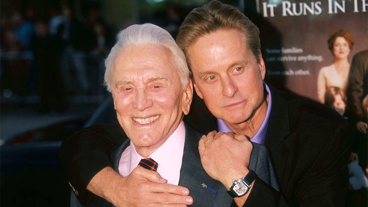 Michael Douglas hangs on his father, Kirk, at the premiere of their new film It Runs in the Family in Los Angeles. (Photo by Kurt Krieger/Corbis via Getty Images)