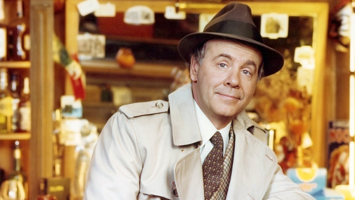 Tim Conway, US actor and comedian, wearing a beige overcoat over a tweed jacket, a white shirt and brown tie, with a brown fedora with a black band, leaning on the back rest of a chair in a studio portrait, circa 1975. (Photo by Silver Screen Collection/Getty Images)