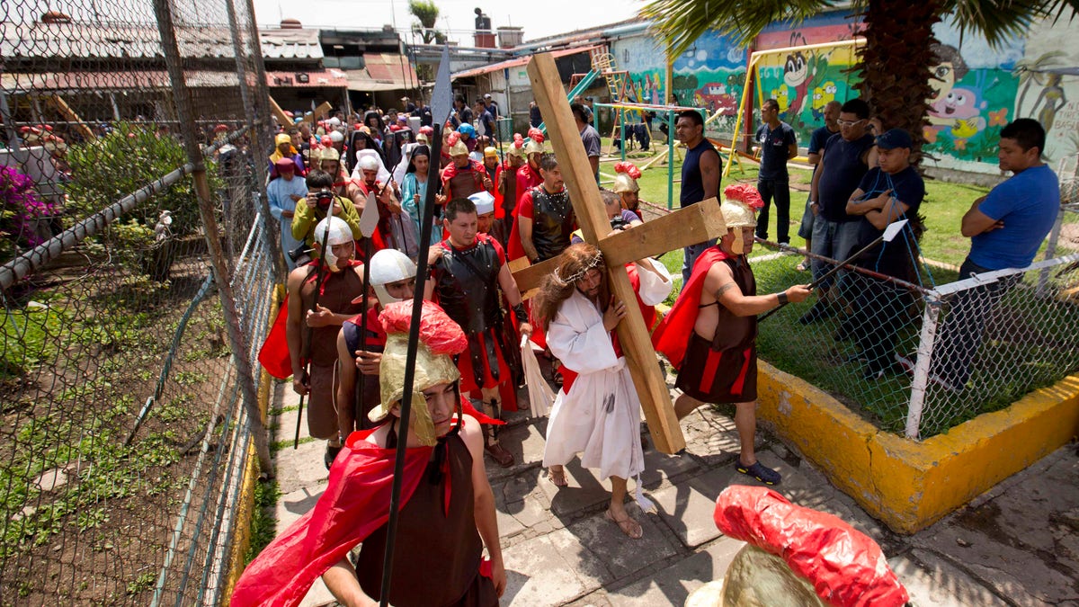 Inmate Aurelio Quevedo, carrying a cross, plays the role of Jesus during a reenactment of the Passion of Christ with fellow prisoners on Good Friday at the Mexico City Penitentiary during Holy Week in Mexico City, Friday, April 3, 2015. ?I behaved badly,? Quevedo said in reference to his crime. ?But all of this leaves a good taste in the mouth, it generates repentance.? Quevedo is a 37-year-old taxi driver serving a 49-year sentence for kidnapping. (AP Photo/Eduardo Verdugo)