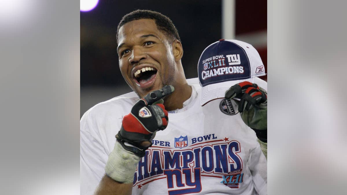 FILE - In this Feb. 3, 2008, file photo, New York Giants defensive end Michael Strahan celebrates after the Giants defeated the New England Patriots 17-14 in the Super Bowl XLII football game in Glendale, Ariz. While Strahan was a game-changer on the field, he was making his mark elsewhere with his gregarious personality, gap-toothed smile and willingness to step out of his comfort zone. He became a regular in commercials, (AP Photo/David J. Phillip, File)