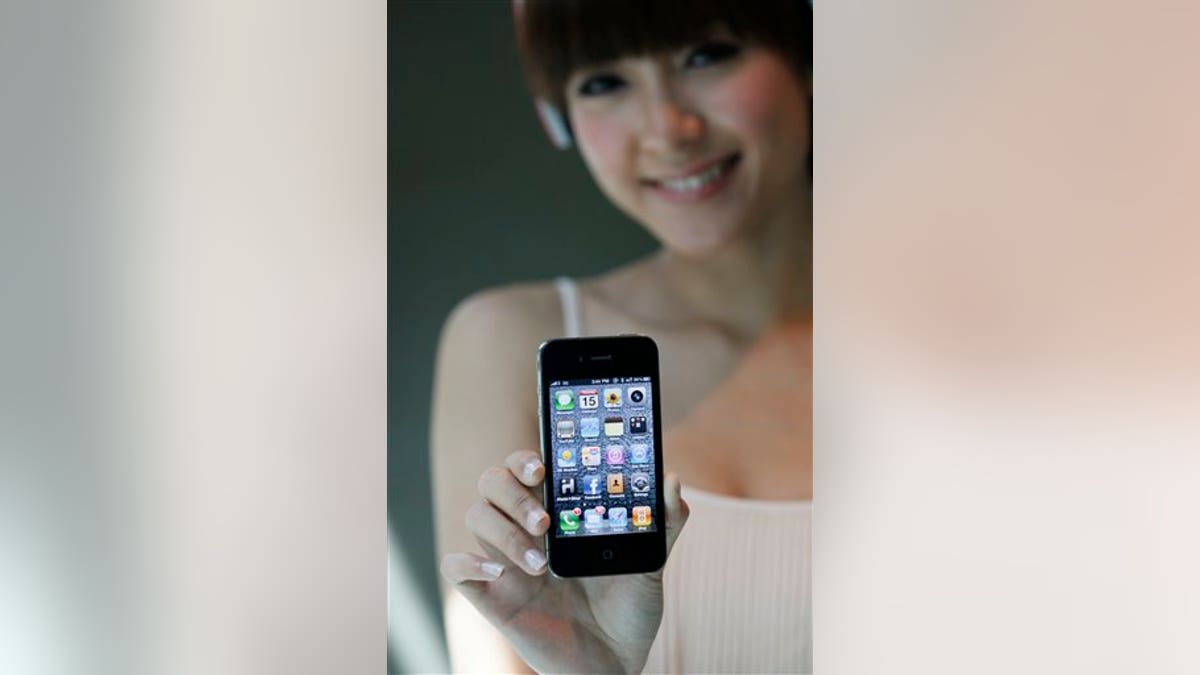 A model holds the latest iPhone 4 during a promotional event in Hong Kong Thursday, July 15, 2010. A decision by Consumer Reports against endorsing the latest iPhone because of reception problems threatens to tarnish Apple Inc.'s reputation, yet fans who have braved poor reception for years are likely to keep buying the product. (AP Photo/Kin Cheung)