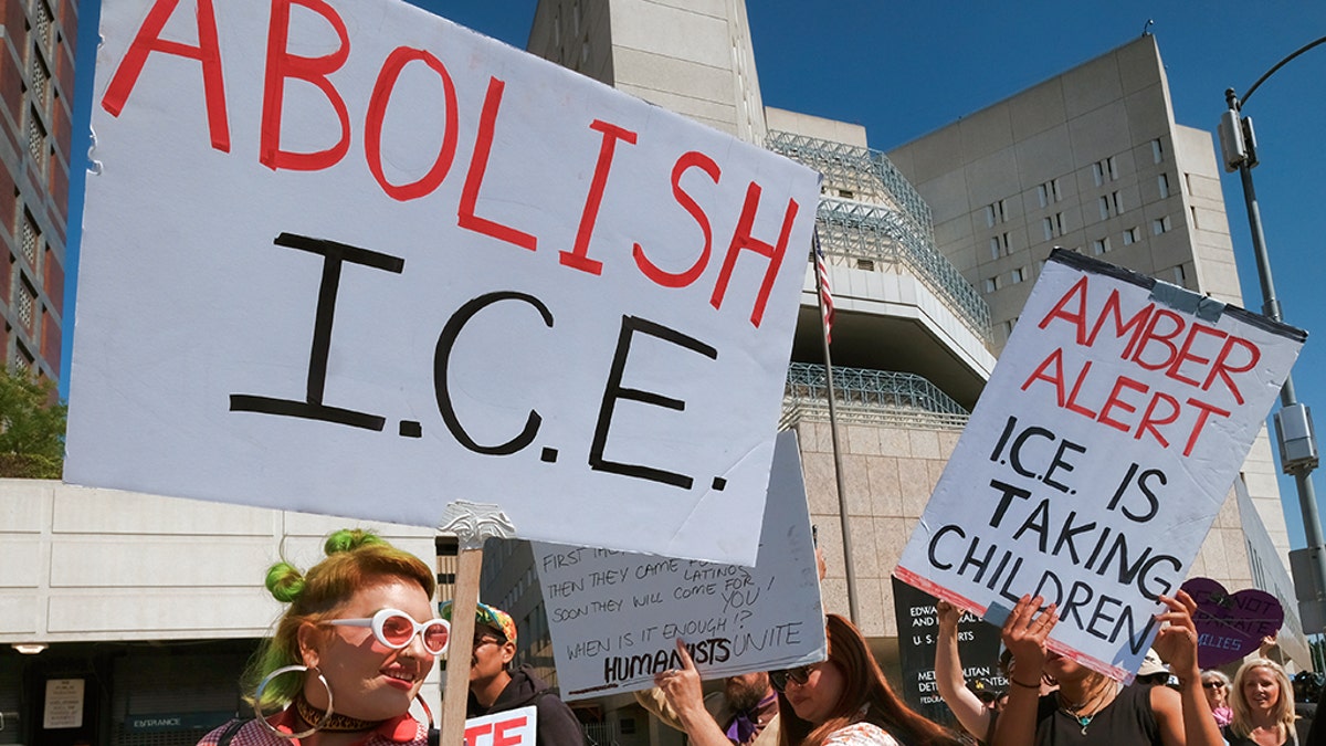 Protesters carry signs during a rally in front of the Immigration and Customs Enforcement facility in downtown Los Angeles on Monday, July 2, 2018.