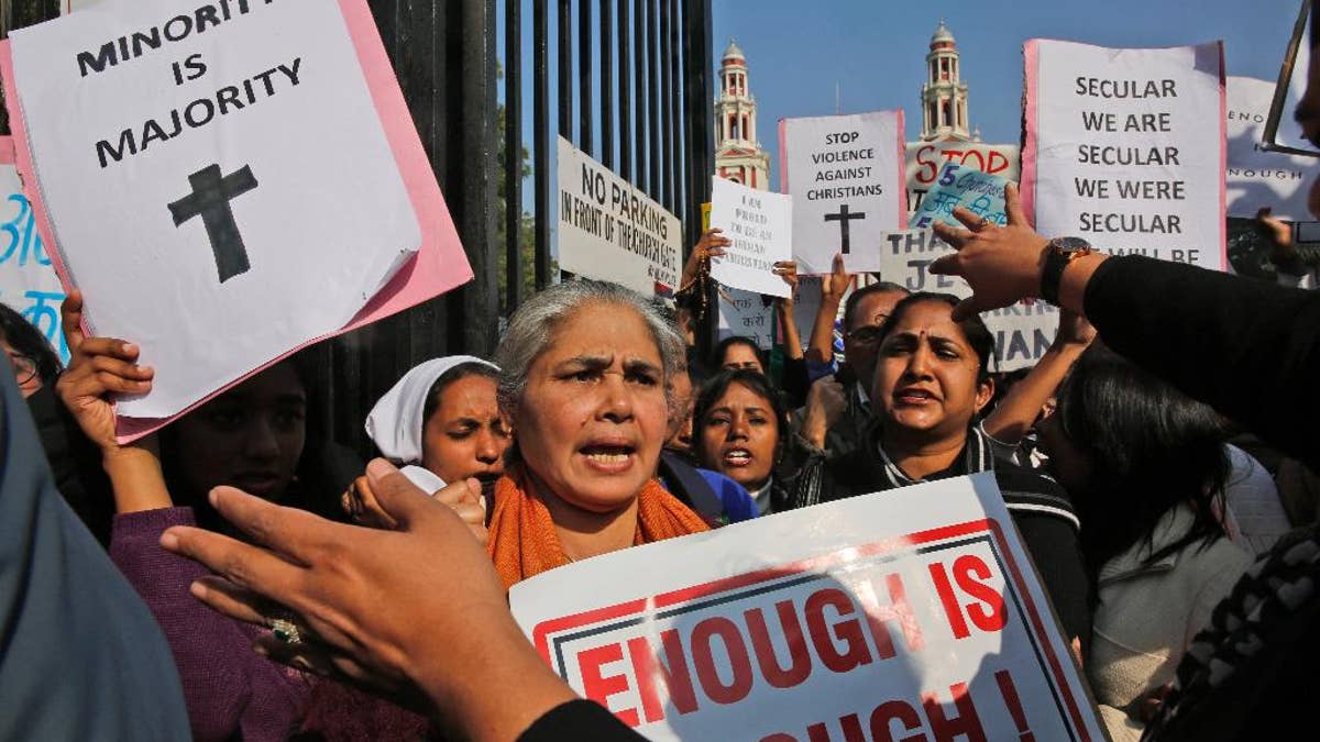 Indian Christians hold placards protesting against attacks on churches in the Indian capital as they assemble outside the Sacred Heart Church in New Delhi, India.