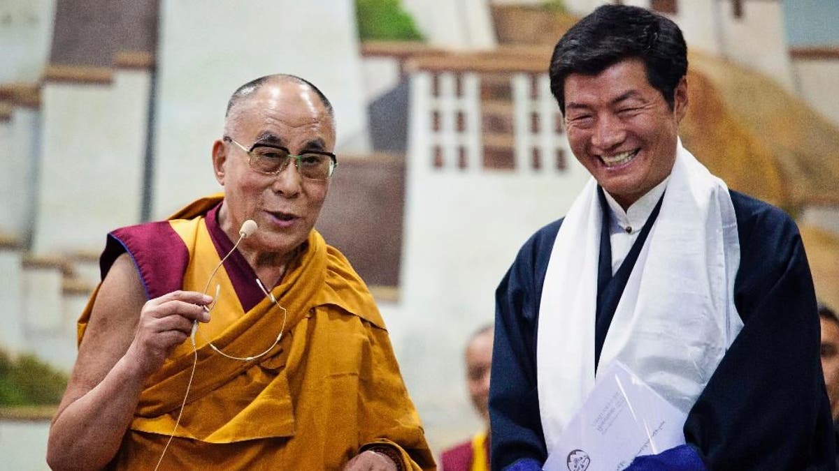 Lobsang Sangay, prime minister of the Tibetan government-in-exile, right, smiles as he listens to spiritual leader the Dalai Lama at the Tibetan Children’s Village School in Dharmsala, India, Thursday, June 5, 2014. The prime minister has reaffirmed Tibet's commitment to the "Middle Way" approach, a way of engaging China in dialogue to achieve a meaningful autonomy for Tibetans within the country. The "Middle Way Approach" was proposed by the Dalai Lama and adopted as an official policy by the exiled parliament in 1997. (AP Photo/Ashwini Bhatia)