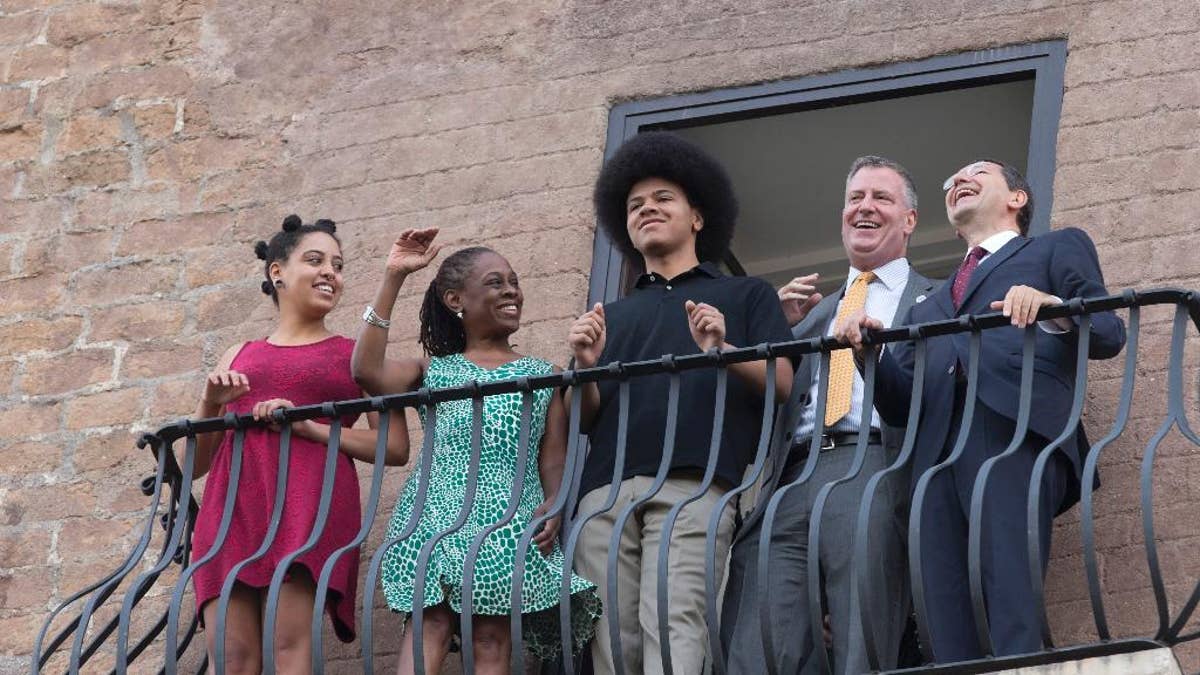 New York City Mayor Bill de Blasio, second from right, shares a laugh with Rome Mayor Ignazio Marino, right, as he is accompanied by his family, from left; daughter Chiara, wife Chirlane McCray, and son Dante, as the look out from a balcony of Rome's Campidoglio, Capitol Hill, overlooking the Roman Forum and Colosseum, Sunday, July 20, 2014. De Blasio and his family are in Italy for a family vacation. (AP Photo/Alessandra Tarantino)