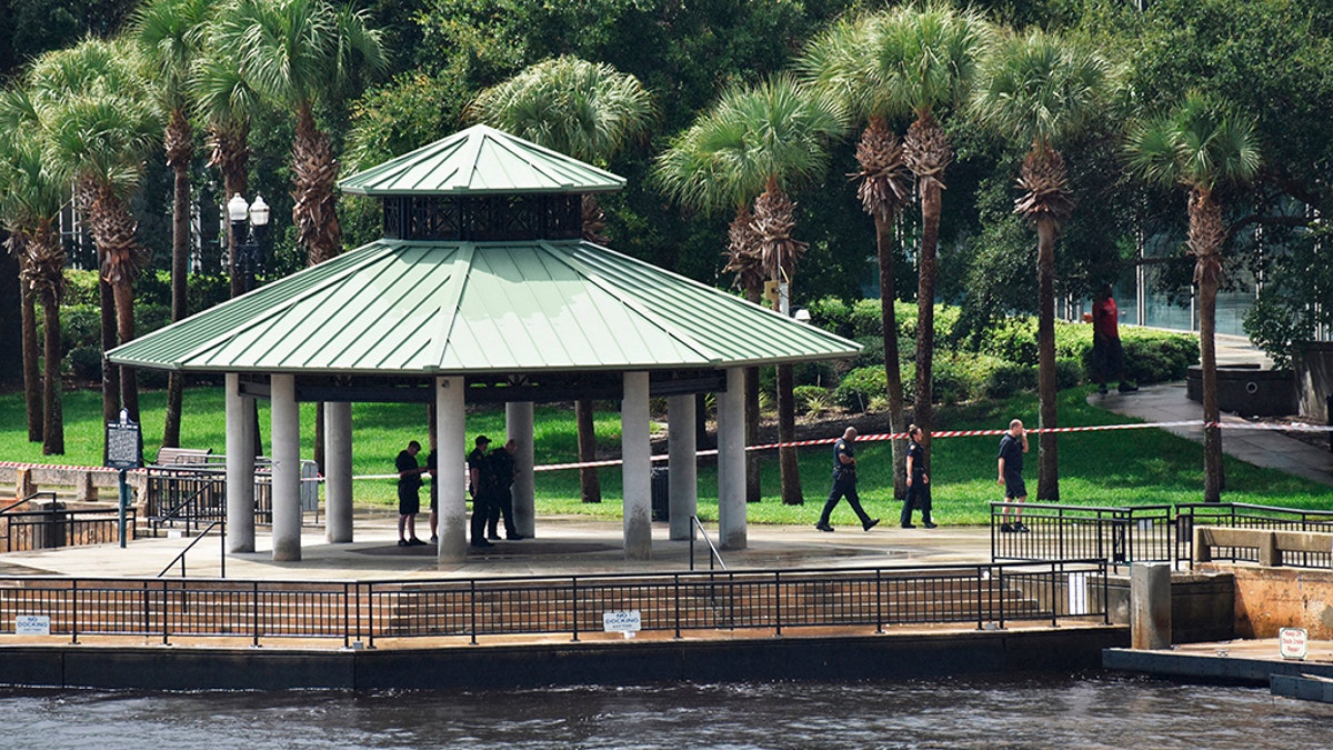 dc94bbfb-Police investigate the scene at the Jacksonville Landing Sunday, Aug. 26, 2018, after a mass shooting during a Madden Championship Series competition