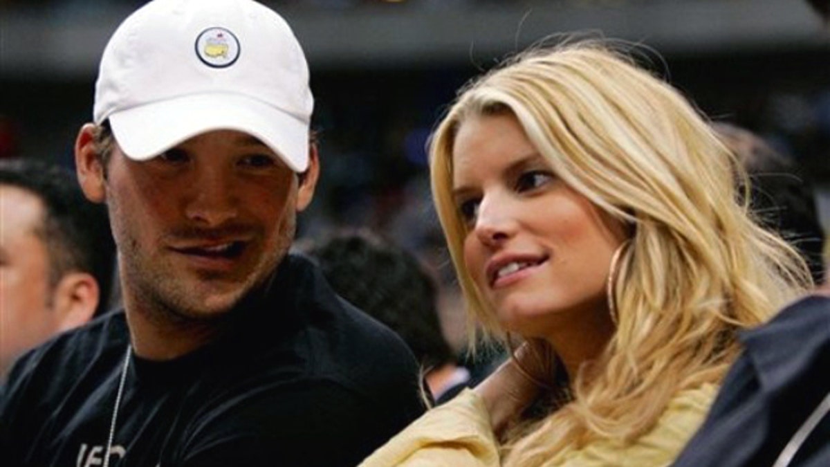 FILE - In this March 18, 2008 file photo, Dallas Cowboys quarterback Tony Romo, left, and actor Jessica Simpson, right, take in an NBA basketball game between the Los Angeles Lakers and Dallas Mavericks in Dallas. (AP Photo/Tony Gutierrez, file)