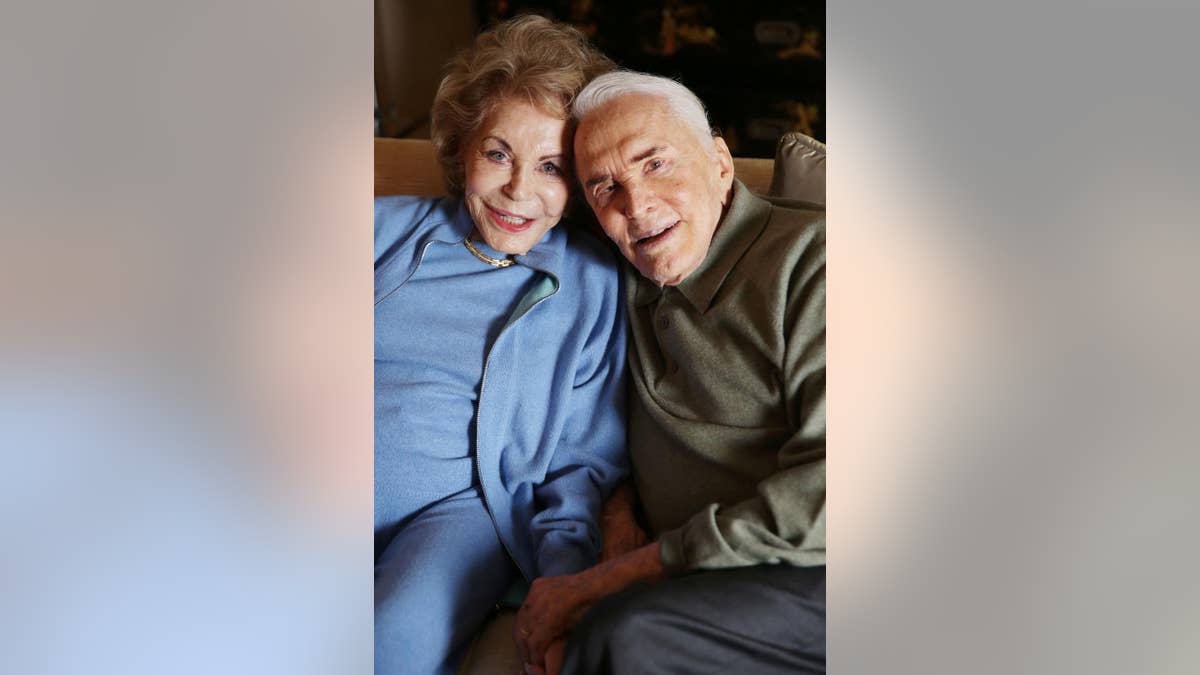 In this Friday, Dec. 5, 2014 photo, Kirk Douglas, right, and wife Anne Douglas pose for a portrait in Beverly Hills, Calif. The rakish screen legend with the famously dimpled chin made it abundantly clear that he was done with writing on a recent overcast afternoon at his Beverly Hills home, days before the release of his poetry collection “Life Could Be Verse: Reflections on Love, Loss, and What Really Matters.” “To me, this is my best book, and my last book,” said Douglas, seated next to his wife of over 60 years. (Photo by Matt Sayles/Invision/AP)