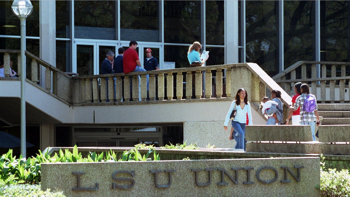 BATON ROUGE, LA - MARCH 14: Students at Louisiana State University make their way at the LSU Union March 14, 2003 in Baton Rouge, Louisiana. LSU student Carrie Lynn Yoder's body was positively identified today, 10 days after she disappeared from her Baton Rouge home, just south of the LSU campus. The young woman's body was found 30 miles west of Baton Rouge on Interstate 10 March 13. Yoder's death is suspected of being part of series of killings of young women in the LSU area in recent months. (L-R)Professor Phil Platt, uncle Jim Yoder, boyfriend Lee Stanton, mother Linda Yoder and father David Yoder look on. (Photo by Mario Villafuerte/Getty Images)