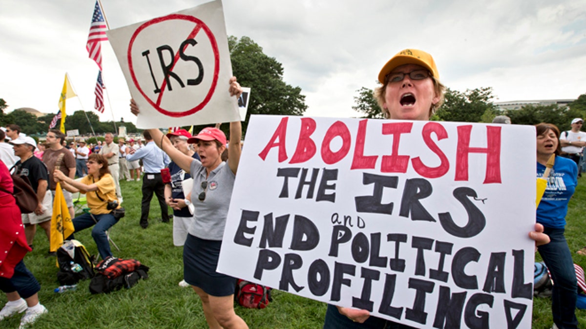 Tea party activists attend a rally on the grounds of the U.S. Capitol in Washington, Wednesday, June 19, 2013. The IRS has been under fire from Democrats and Republicans in Congress since May, when one of its officials publicly apologized for targeting conservative groups' applications for tax-exempt status for close examination. (AP Photo/J. Scott Applewhite)