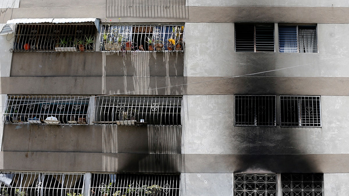 Signs of smoke cover the apartment complex where an allegedly armed drone crashed, causing a fire, in Caracas, Venezuela, Sunday, Aug. 5, 2018.