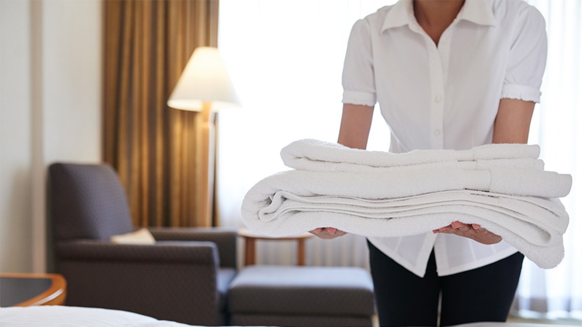 Hotel maid bringing fresh towels to the room