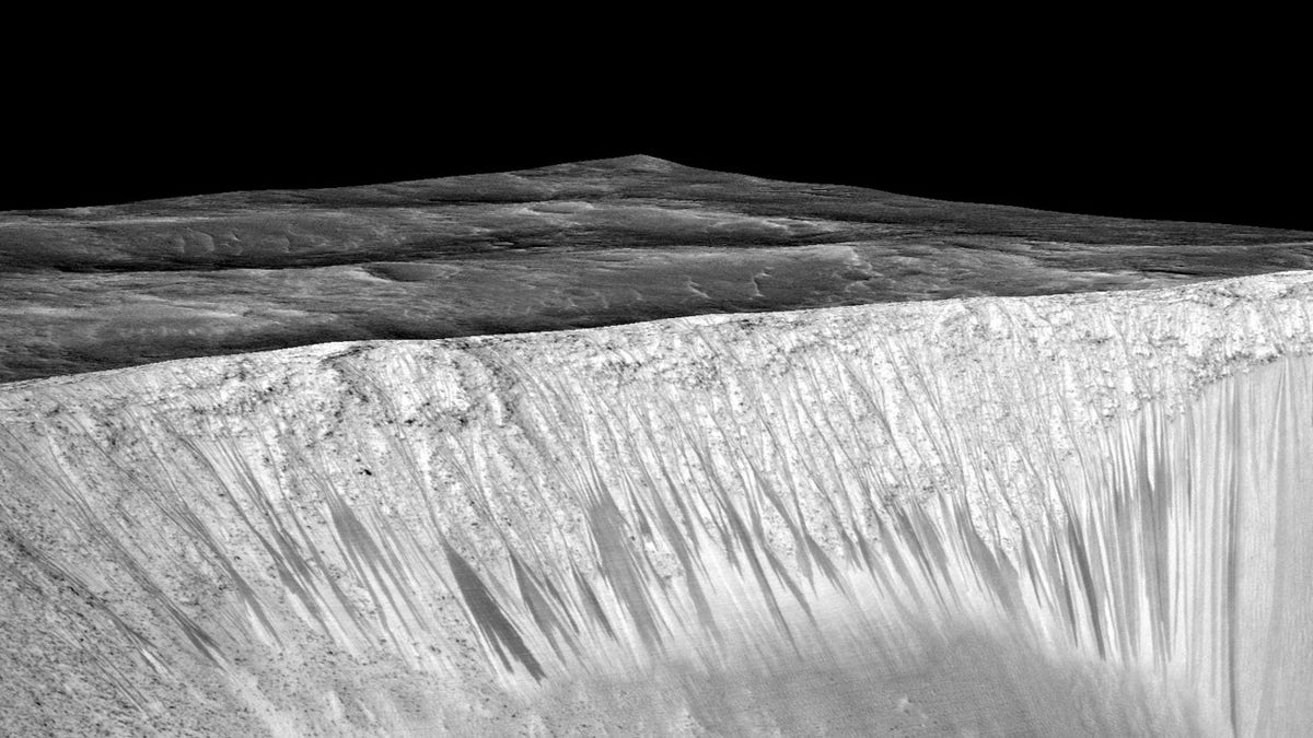 Dark narrow streaks called recurring slope lineae emanating out of the walls of Garni crater on Mars.