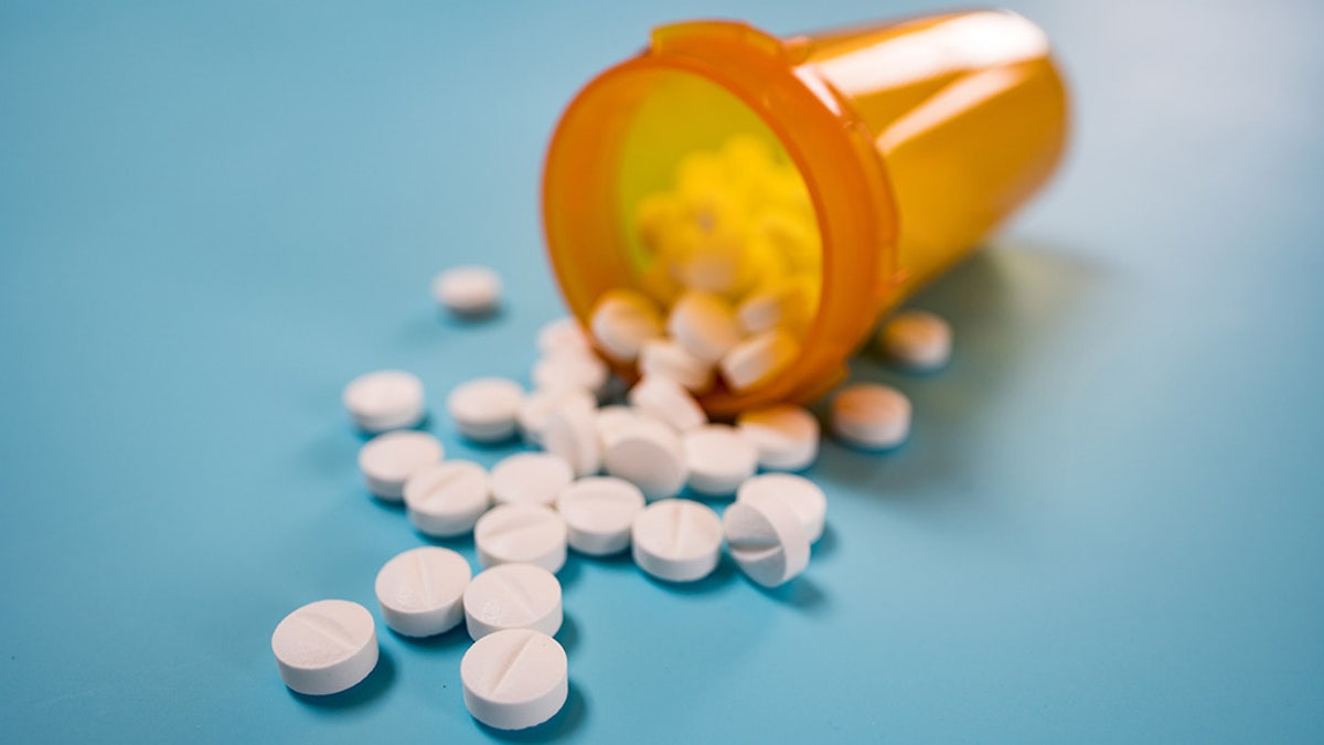 Pile of white pills on blue background