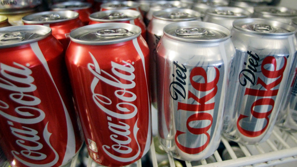 FILE - In this March 17, 2011, file photo, Cans of Coca-Cola and Diet Coke sit in a cooler in Anne's Deli in Portland, Ore. A nonprofit founded to combat obesity says the $1.5 million it received from Coke has no influence on its work. But emails obtained by The Associated Press show the worlds largest beverage maker was instrumental in shaping the Global Energy Balance Network, which is led by a professor at the University of Colorado School of Medicine. Coke helped pick the groups leaders, edited its mission statement and suggested articles and videos for its website. (AP Photo/File)