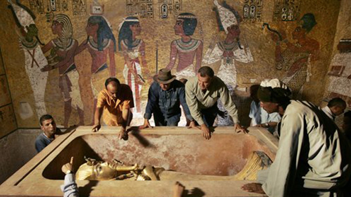 FILE - In this Sunday, Nov. 4, 2007 file photo, Egypt's antiquities chief Dr. Zahi Hawass, center, supervises the removal of King Tut from his stone sarcophagus in his underground tomb in the famed Valley of the Kings in Luxor, Egypt. Egypt will soon reveal the results of DNA tests made on the world's most famous ancient king, the young Pharaoh Tutankhamun, to answer lingering mysteries over his lineage, said the antiquities department Sunday, Jan. 31, 2010. (AP Photo/Ben Curtis, Pool, File)