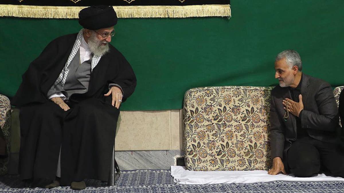 FILE - In this Friday, March 27, 2015 file photo released by the official website of the office of the Iranian supreme leader, commander of Iran's Quds Force, Qassem Soleimani, right, greets Supreme Leader Ayatollah Ali Khamenei while attending a religious ceremony in a mosque at his residence in Tehran, Iran. The chief of an elite unit in Iran's Revolutionary Guard has accused the U.S. of having 