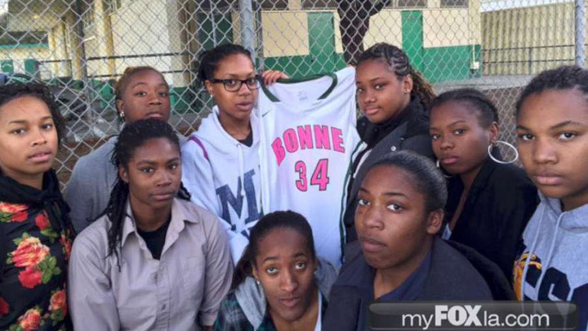 Pelatih bola basket sekolah menengah atas mengenakan seragam merah jambu para pemainnya karena kesadaran akan kanker payudara