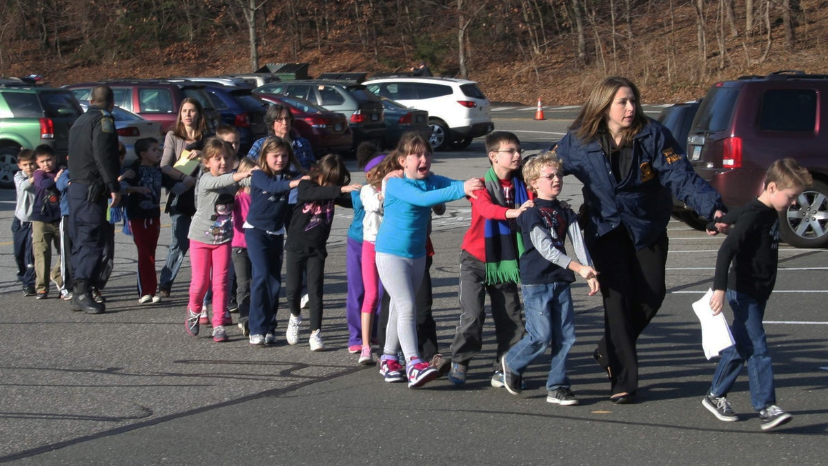 FILE - In this photo provided by the Newtown Bee, Connecticut State Police lead a line of children from the Sandy Hook Elementary School in Newtown, Conn. on Friday, Dec. 14, 2012 after a shooting at the school.  Recordings of 911 calls from the Newtown school shooting are being released Wednesday Dec. 4, 2013, days after a state prosecutor dropped his fight to continue withholding them despite an order to provide them to The Associated Press. (AP Photo/Newtown Bee, Shannon Hicks, File) MANDATORY CREDIT: NEWTOWN BEE, SHANNON HICKS