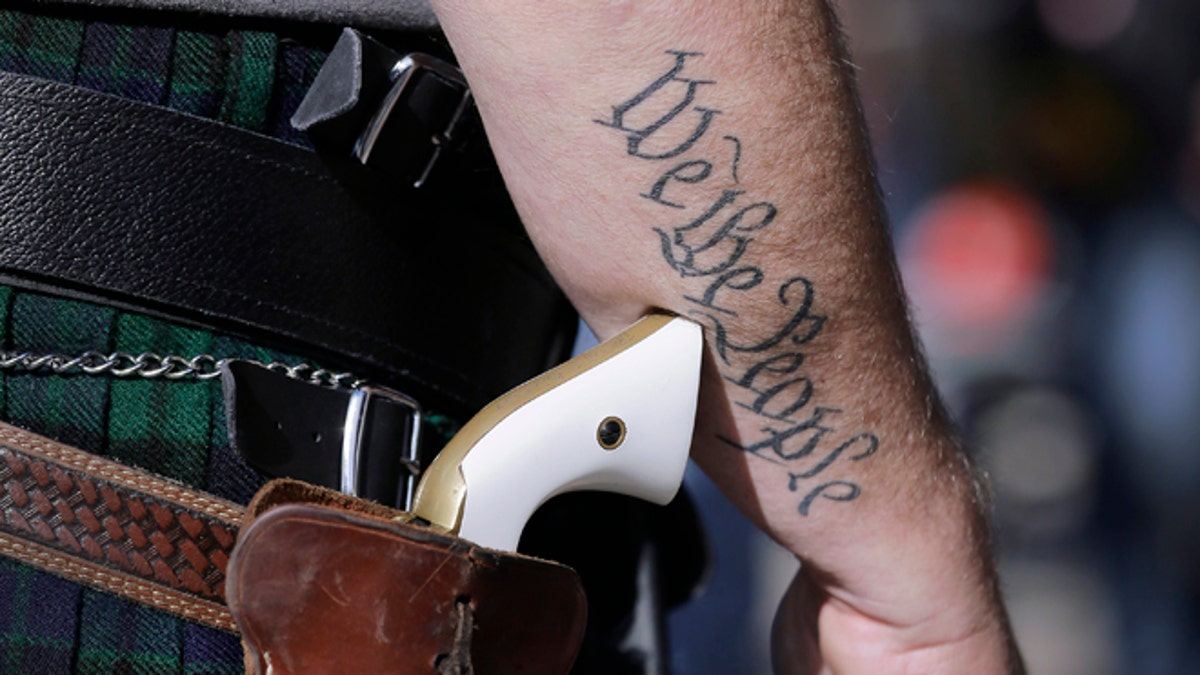 FILE - In this Jan. 26, 2015, file photo, Scott Smith, a supporter of open carry gun laws, wears a pistol as he prepares for a rally in support of open carry gun laws at the Capitol, in Austin, Texas. Despite its reputation as the trigger-happy heart of American gun culture, Texas is late to the open carry party, at least when it comes to handguns. On New Yearâs Day, itâll become the 45th state to legalize carrying a pistol in plain sight. (AP Photo/Eric Gay, File)