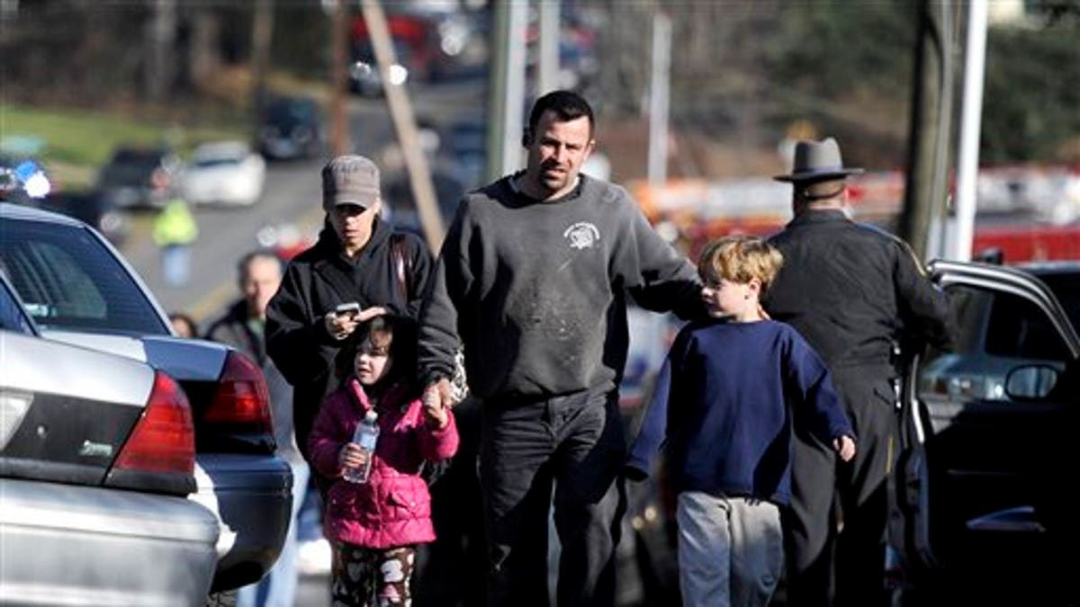 Parents leave a staging area after being reunited with their children following a shooting at the Sandy Hook Elementary School in Newtown, Conn., about 60 miles (96 kilometers) northeast of New York City, Friday, Dec. 14, 2012. An official with knowledge of Friday's shooting said 27 people were dead, including 18 children. It was the worst school shooting in the country's history. (AP Photo/Jessica Hill)