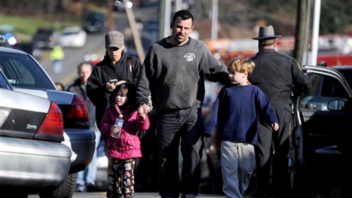 Parents leave a staging area after being reunited with their children following a shooting